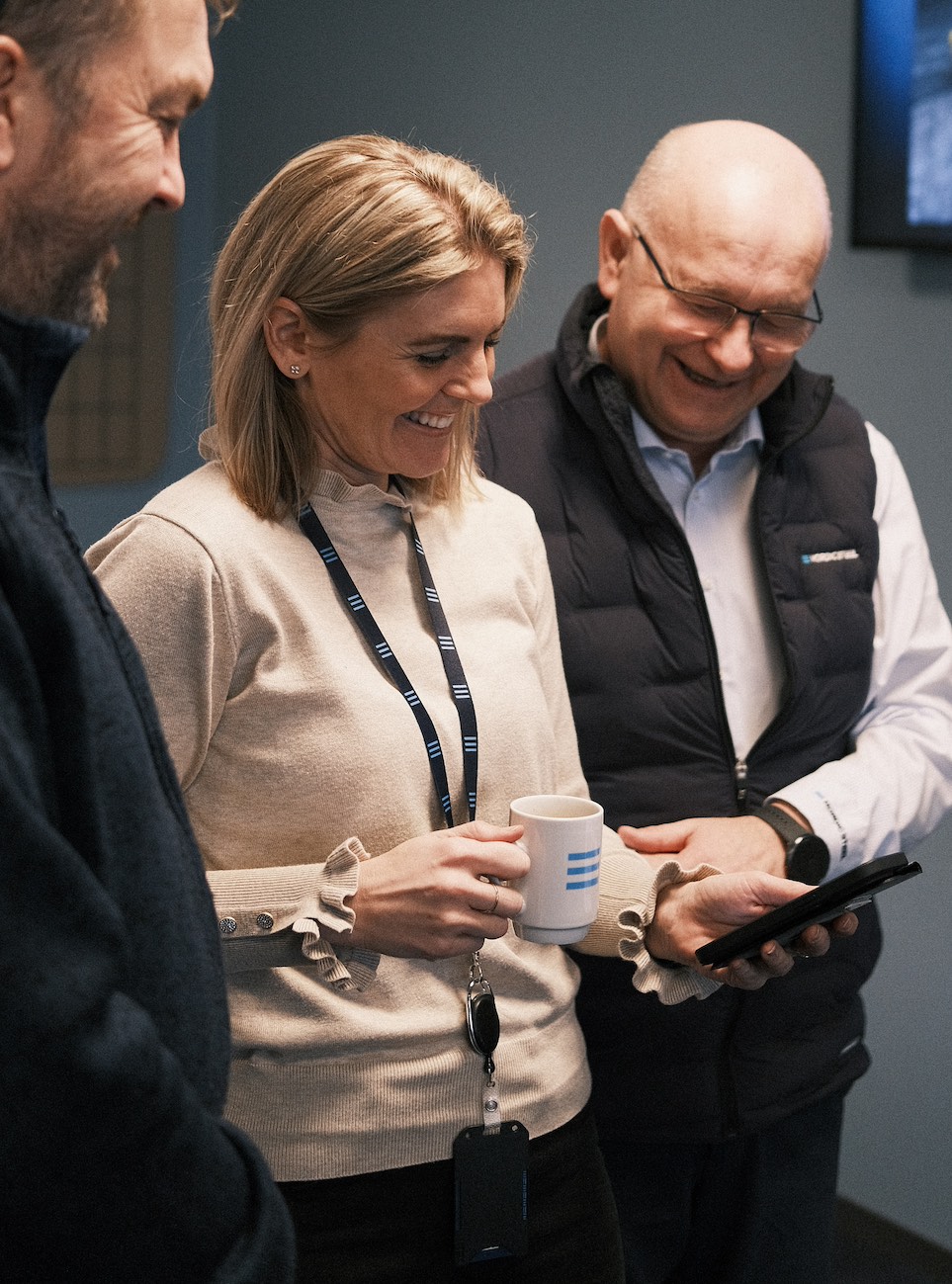 Tre tilsette ved Nordic Steel kikkar på appen